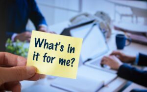 A post it note that reads "What's in it for me?"